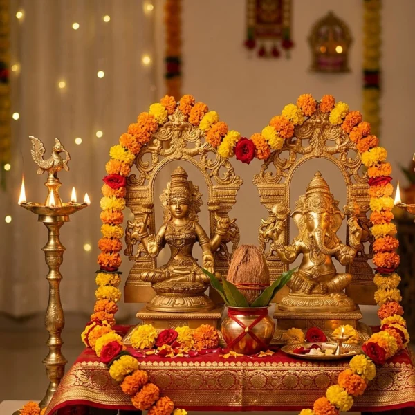 Brass Laxmi Ganesh pair, 13 inch, on a red and gold cloth with lit deepak stands, kalash and marigold garlands for Diwali puja